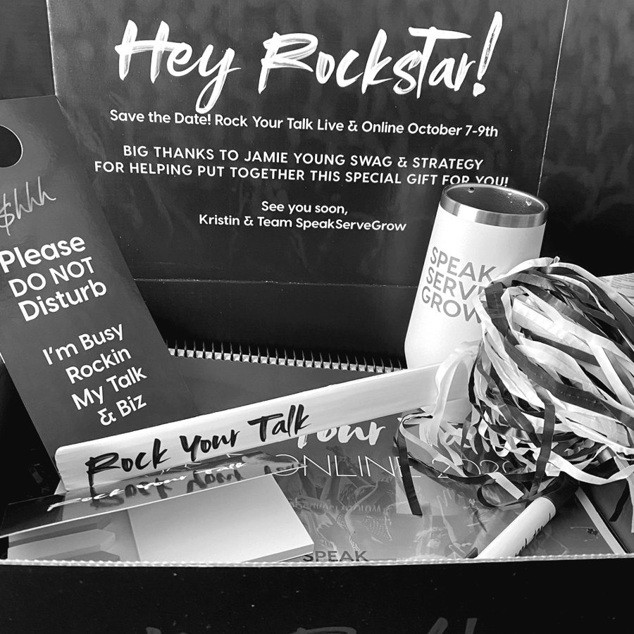 An open gift box with a branded tumbler, notebook, and Rock Your Talk door hanger.